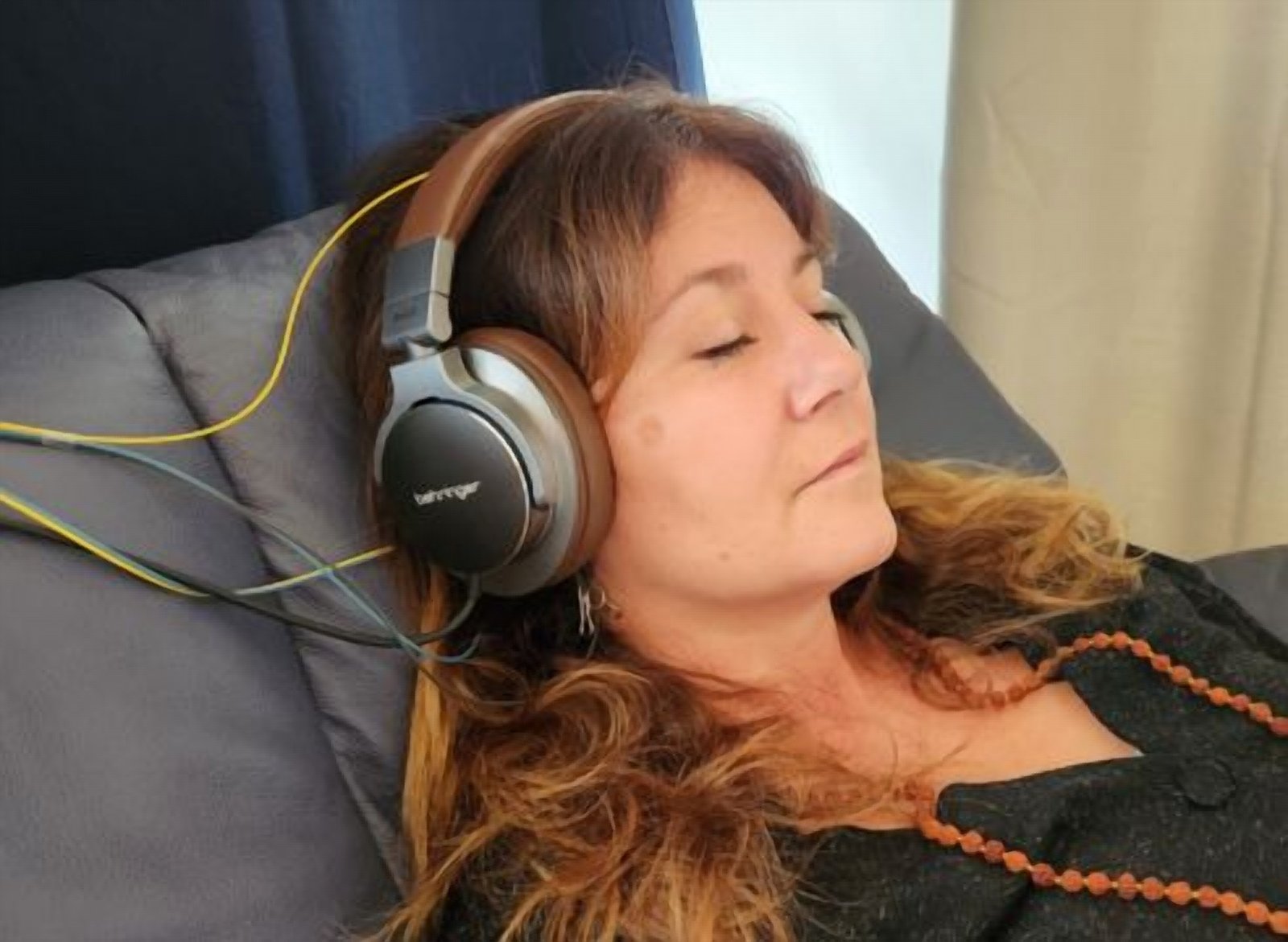 Cliente installée confortablement pendant une séance de Neurofeedback Dynamique NeurOptimal®, casque et capteurs posés